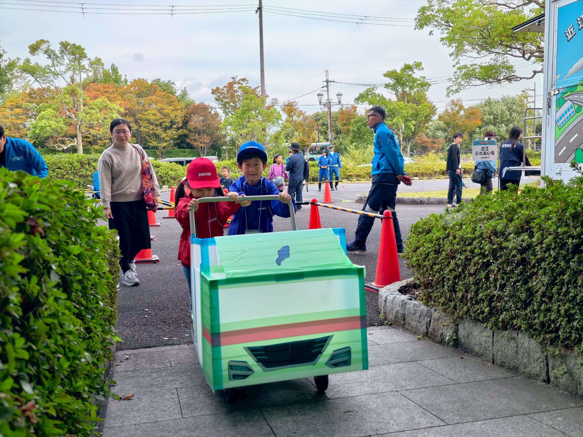 手作りのトラックを押して荷物を届ける子どもたち